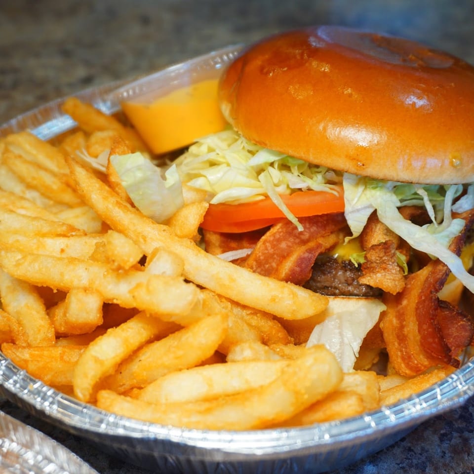 A Pantano's Eatery bacon cheeseburger with lettuce and tomato, served with a side of fries.