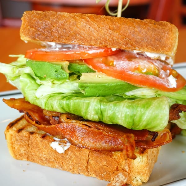 A toasted sandwich from Pantano's Eatery, filled with bacon, lettuce, avocado, and tomato.